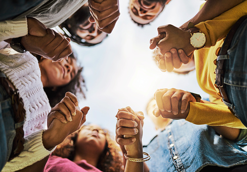 People holding hands in a circle.